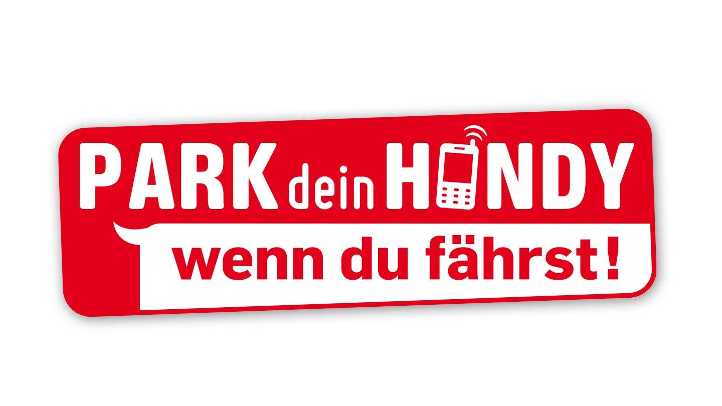 Kind auf Zebrastreifen mit Ball. Im Hintergrund Autofahrer mit Handy